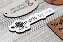 White acrylic label with 'made by me' text and needle and button motif - Item no. 3003