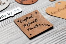 Brown faux leather label with laser-engraved 'Crafted. Refined. Timeless.' text - Item no. 3003