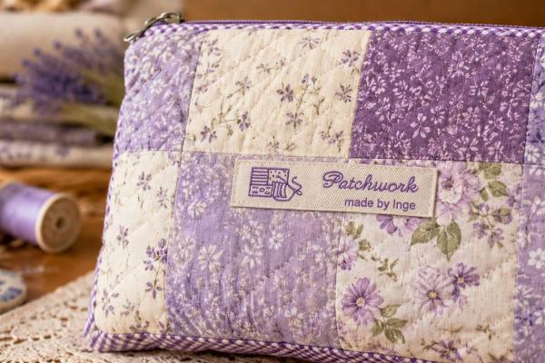 Natural cotton label with purple lettering on patchwork pouch
