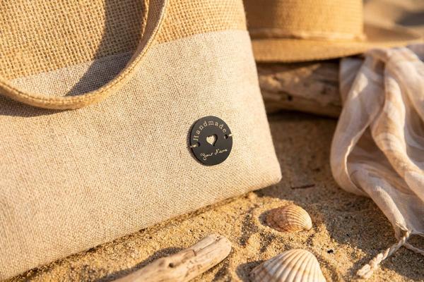 Round stainless steel label on jute bag with heart cutout