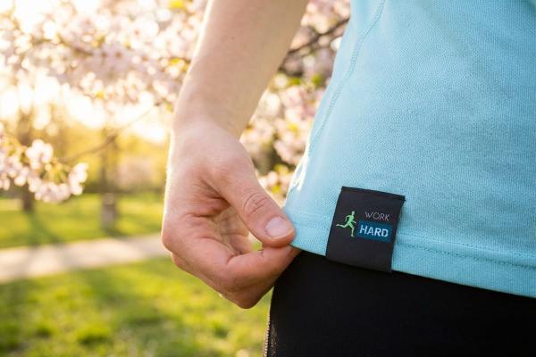 Black satin label attached to the hem seam of a sports shirt