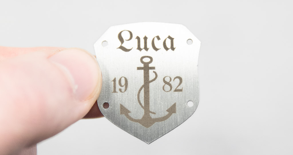 Coat of arms-shaped metal label, brushed stainless steel
