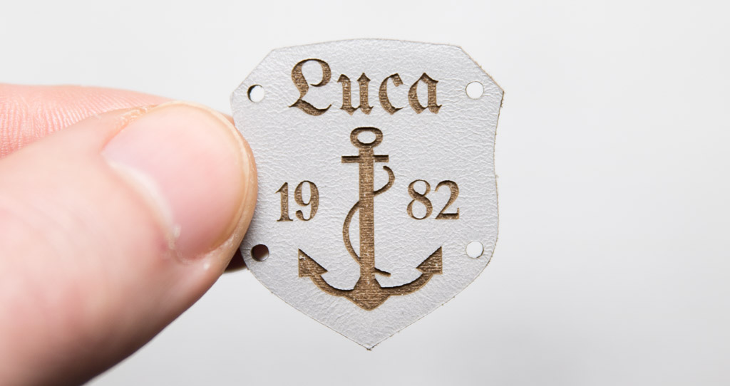 Gray leather label, coat of arms with motif and text
